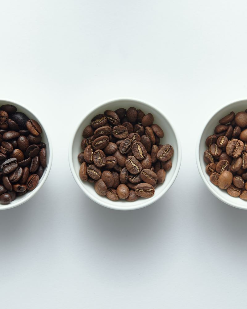 Três tigelas com café em torra escura, média e clara